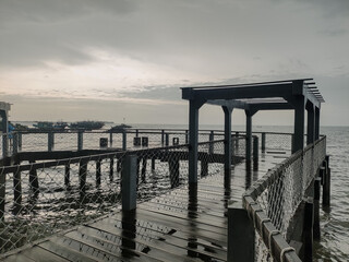 Beach view with cloudy weather on the edge of the pier. Bad weather concept at sea