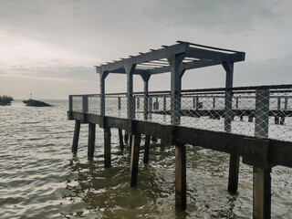 Beach view with cloudy weather on the edge of the pier. Bad weather concept at sea