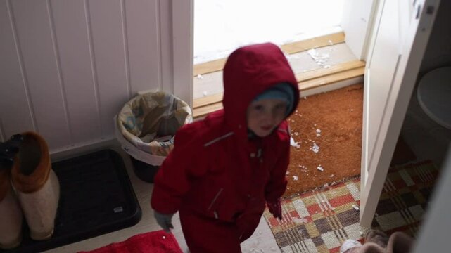 a child came from the street and calls his mother to undress him a child came from a winter walk dlm with an open door for winter a jumpsuit for winter a child came from a walk