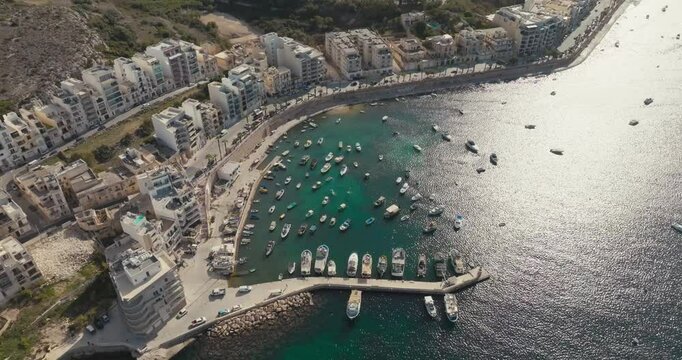 Drone View of Bugibba Malta Marina Featuring Urban Cityscape on the Mediterranean with Tourist Beaches and Yachts Moored on the Waterfront. High quality 4k footage