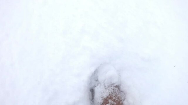 man walking in the snow in blue pants and ugg boots girl walking in the snow in warm shoes and warm pants white snow and steps on it athletic gait in the snow deep snow underfoot