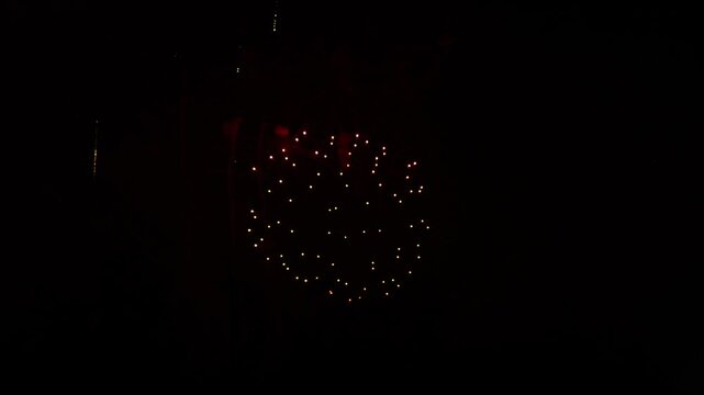 Golden purple green sparks scattering fireworks on the black night sky. General plan