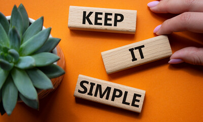 Keep it Simple symbol. Concept words Keep it Simple on wooden blocks. Businessman hand. Beautiful...
