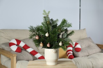Obraz premium Decorated fir tree branches on table at home. Christmas decor