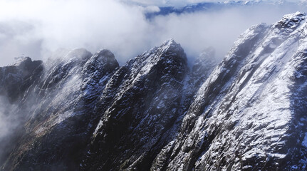 Majestic snowcapped mountain peaks rise majestically under an expansive cloudy sky above