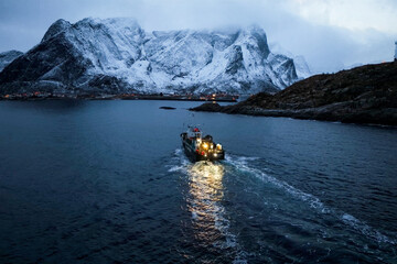 A fishing boat skillfully navigating through the snowy waters as dusk falls upon the horizon