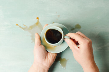 Senior suffering from Parkinson neurodegenerative disease or arthritis, shaking hand spills coffee,...
