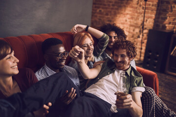 Friends laughing and drinking beer at a cozy bar