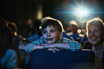 Grandparents enjoying a movie with grandson in the theater