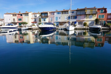 Port Grimaud, south of France with colorful buildings and boats moored in the marina with a mirror reflection