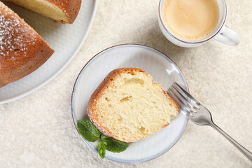 Piece of freshly baked sponge cake, mint and coffee on white textured table, top view