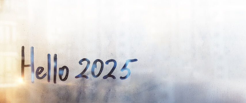 Banner lettering Hello and numbers 2025 is twenty twenty-five of new year paint with finger on splashed by rain foggy blue glass on window with sunset , copy space