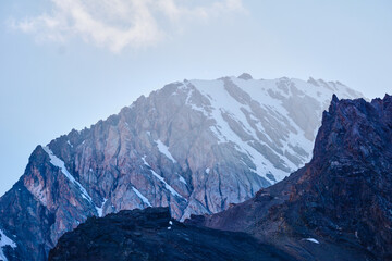 Fototapeta premium dawn in the mountains , the first rays of the sun illuminate the mountain peaks in the snow