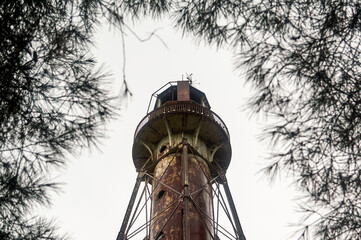 Old rusty lighthouse against the grey sky