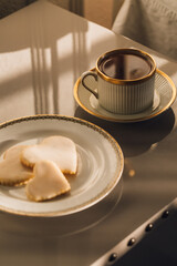 elegant cup of tea and plate of iced heart shaped sugar cookies