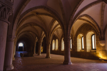 cloister with a series of arches supported by elegant columns, creating a grand and awe-inspiring interior space bathed in warm light