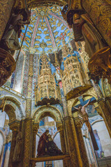 Obraz premium historic interior with intricately carved stone columns and stained glass windows reaching towards a vaulted ceiling, creating a sense of awe and wonder.