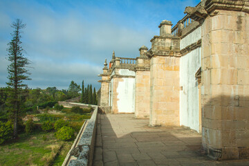 weathered stone facade with ornate details, a decorative window, and a glimpse of a landscaped...