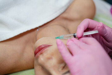 The master cosmetologist shows cosmetology students the technique of how to do biovelitarization in the face. Cosmetology. Youth. Beauty