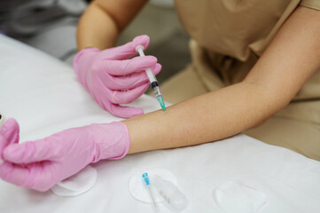 A cosmetologist student is undergoing training and learning how to inject meso on his hand. There are traces and blood on the hand from the injection of the drug. Cosmetology