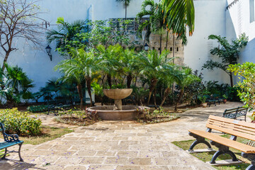 A courtyard with a fountain and a bench