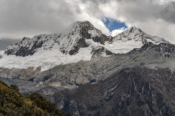 Fototapeta premium Breathtaking winter landscape featuring snow-covered mountains under a beautiful misty sky.