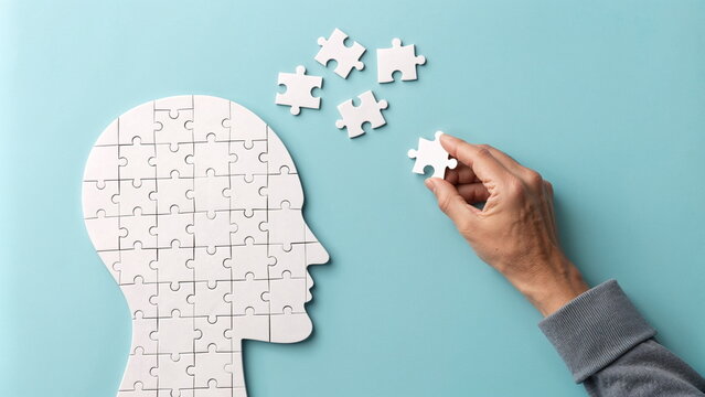 Hand completing puzzle head on blue background