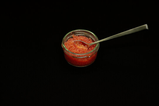 red lumpfish roe in a glass jar isolated on black