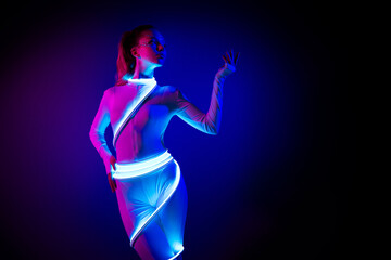Attractive chic lady robot with led light cable posing demonstrate with hands empty space...