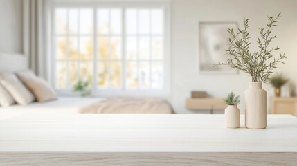 Empty white table top in front of blurred bedroom background. Cozy, bright bedroom interior. Wooden vases with plants add natural touch. Peaceful, serene interior style. Suitable for home decor
