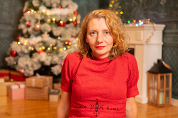 woman in red clothing in front of Christmas tree