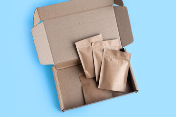 Kraft brown paper empty bags isolated mock up on light blue background. Eco friendly pack with zipper, roasted specialty coffee beans, tea, snack, alternative sample trendy concept. top view, flat lay