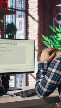 Software developer at computer waiting for code to finish compiling, yawning, feeling bored. Impatient man tired to wait for algorithms building scripts to finish, camera A