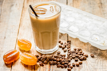 iced coffee with beans for cold summer drink on wooden background