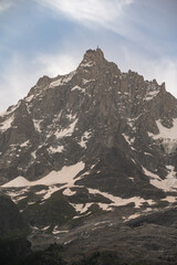 Tour du Montblanc beautiful mountain ladscapes of the Alps green valley, snow summit of Montblanc and rocky peaks of Aiguille du Midi in summer sunny weather blue sky, trekking and hiking in Chamonix
