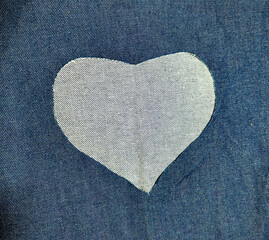 the heart forms an opening in the blue denim.