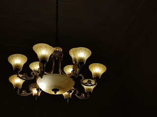 Classic and vintage chandeliers in the dark room. Copy space for background.