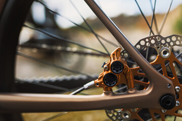 Orange brake caliper with floating disc on a gravel wheel.