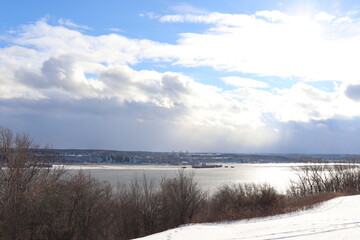 Winter landscape and the St-Laurent river with a blue cloudy sky. Outdoor activities in winter and...