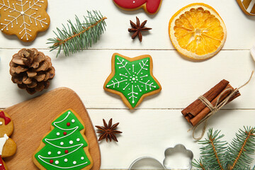 Tasty Christmas cookies with decor on white wooden background