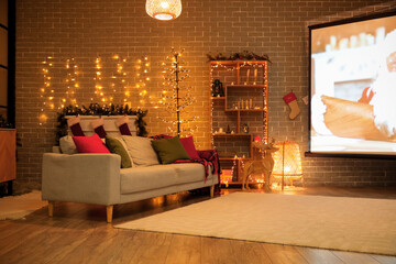 Interior of living room with Christmas lights, sofa and projector screen