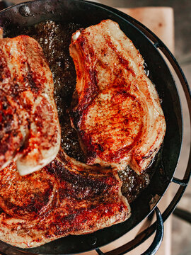 Seared pork chops on a hot steel pan