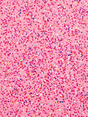 A vibrant pink background sprinkled with colorful confetti-like dots.