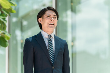 Fototapeta premium 会社・オフィスに出勤・出社・通勤する若い男性アジア人ビジネスマン 