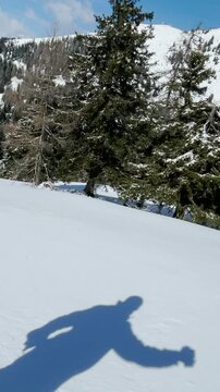 VERTICAL, SELFIE: Young Caucasian man and woman splitboard in the picturesque Slovenian backcountry on a sunny day. Tourist couple shreds fresh powder snow during a split boarding trip in Slovenia.