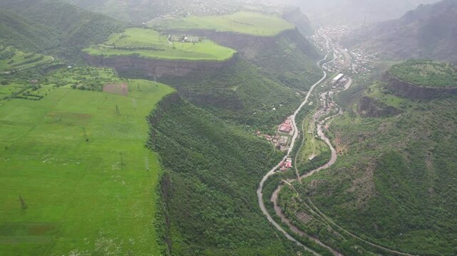 Forward reveal aerial shot of Debed river valley between Haghpat and Sanahin villages on sunny spring day. Armenia.