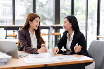 Business financing accounting banking concept. Two asian Business doing finances and calculate on desk about cost at workplace. Business working on desk with using calculator, finance accounting.
