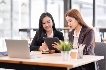 Business financing accounting banking concept. Two asian Business doing finances and calculate on desk about cost at workplace. Business working on desk with using calculator, finance accounting.
