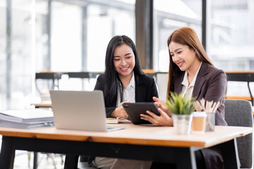 Business financing accounting banking concept. Two asian Business doing finances and calculate on desk about cost at workplace. Business working on desk with using calculator, finance accounting.
