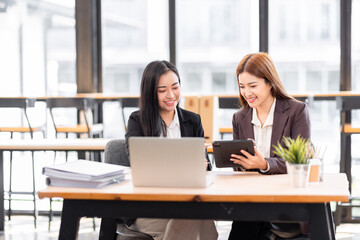 Business financing accounting banking concept. Two asian Business doing finances and calculate on desk about cost at workplace. Business working on desk with using calculator, finance accounting.
